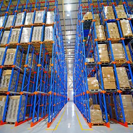 Drive-In Racking System in a modern warehouse featuring blue and orange steel racks designed for high-density pallet storage.
